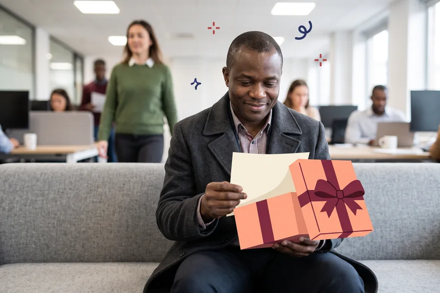 Man on an office sofa reading the first page of a journal he just unwrapped