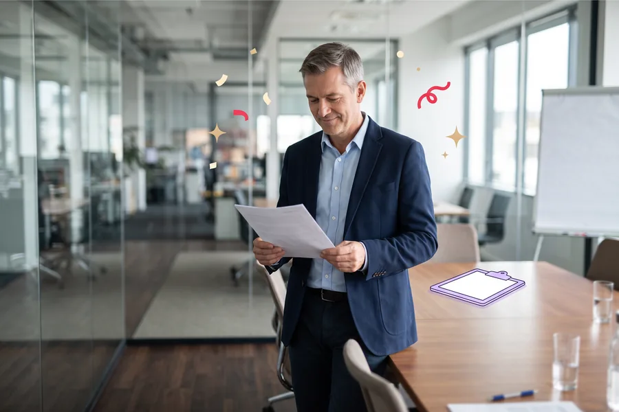 Man in a glass meeting room reading a printed report